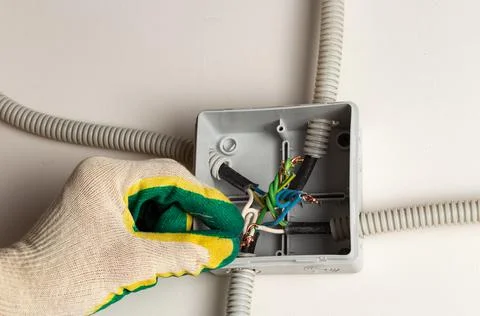 Gloved hand mounts wire insulation. the concept of repairing electrical Foto stock