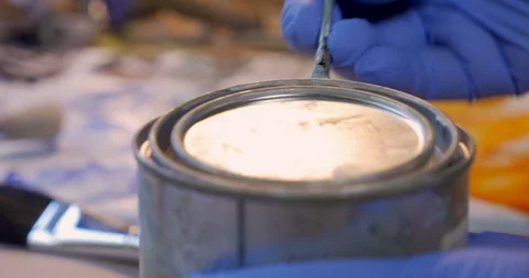 Gloved hand opening a small can of cold wax or artist paste - close up Stock Footage 120638627