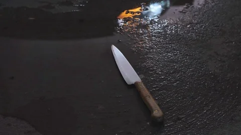 A gloved hand picks up a knife from the ground Stock Footage 116961667