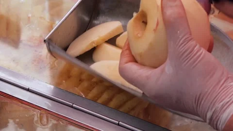 Gloved Hand Placing Fresh Apple Slices into Industrial Food Processing Machine Stock Footage 345650947