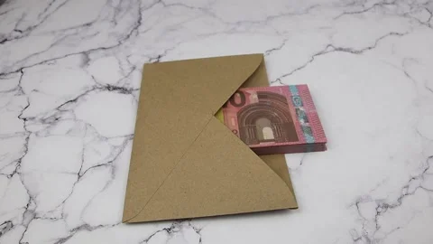 A gloved hand puts a bucket of 10 euro banknotes on an envelope with banknotes Vidéo 145535169