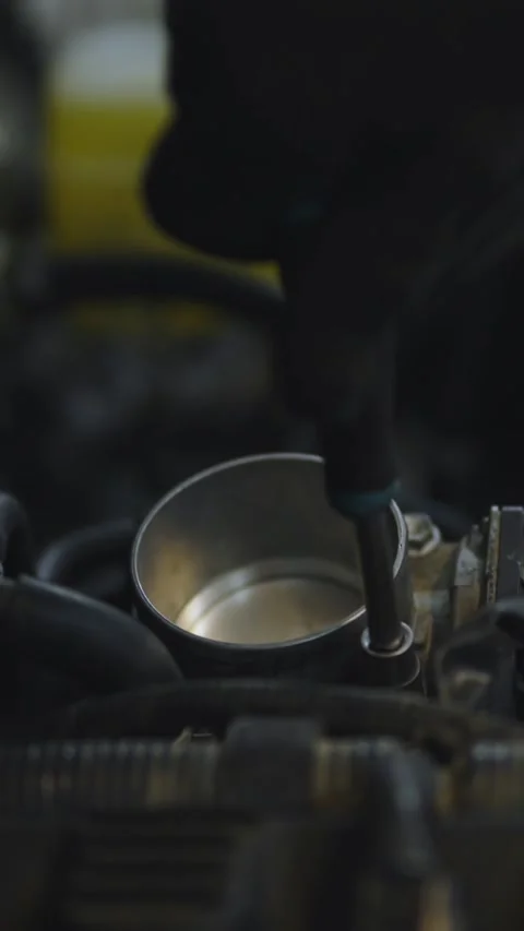 A gloved hand reaches past an open throttle body inside a car engine Stock Footage 336710596