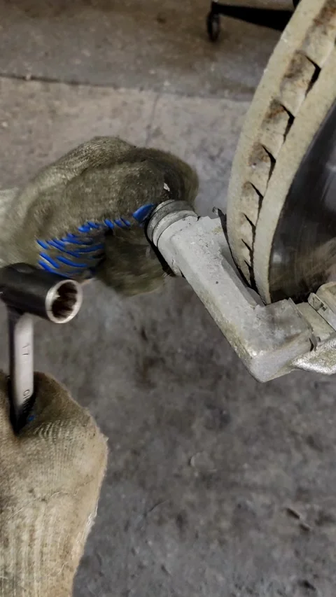 Gloved hand removing a slide pin from a brake caliper Stock Footage 333701749