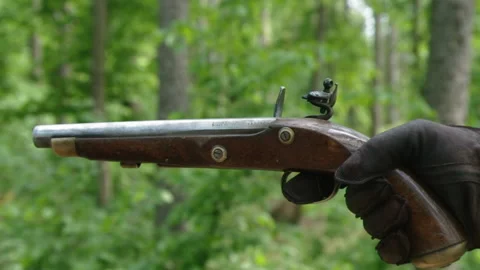 Gloved hand squeezes trigger to fire old flintlock pistol, close-up Stock-Footage 131085174