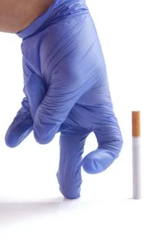 Gloved hand throwing cigarette Quit smoking metaphor Stock Photos
