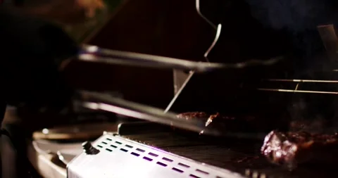Gloved Hand Turning Steaks on Gas Grill, Closing the Lid, Medium Shot Stock Footage 340322288