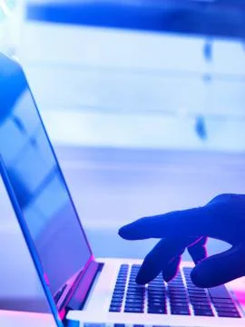 Gloved hand typing and hacking laptop computer 스톡 사진