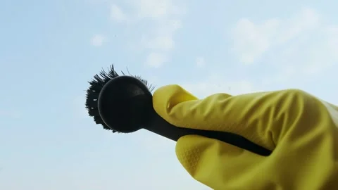 Gloved hand uses a brush to remove dirt, holding a spray and cloth that perfectl Stock Footage 301307556