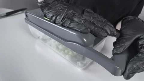 Gloved hand uses a modern vegetable chopper dicing fresh white onion cubes,.. Stock Footage 322795120