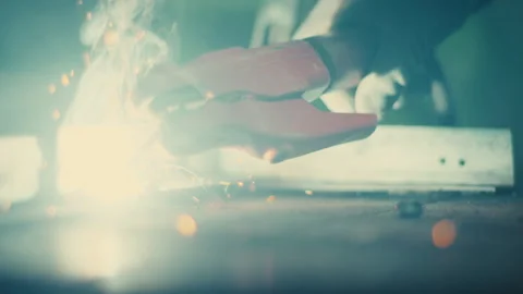 Gloved hand welding metal with bright arc and flying sparks close up Stock Footage 331696498