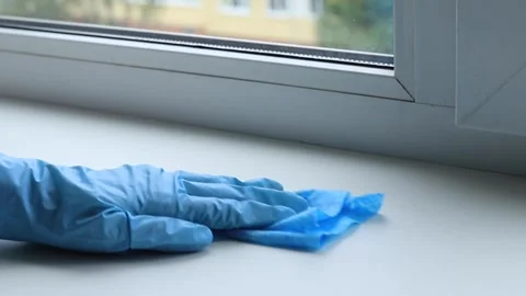Gloved hand wiping window sill with blue cloth. Domestic housekeeping maint.. Stock Footage 346784798