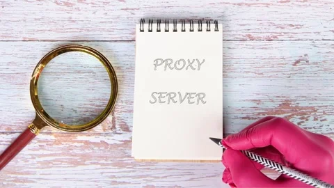A gloved hand writes Proxy Server on a small spiral notepad with a pen. A Video stock 328072737