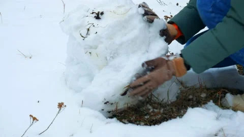 Gloved hands are pushing a large snowball. Stock Footage 221745049