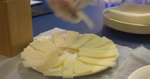 Gloved hands arranging cheese slices on a paper plate Stock Footage 302338784