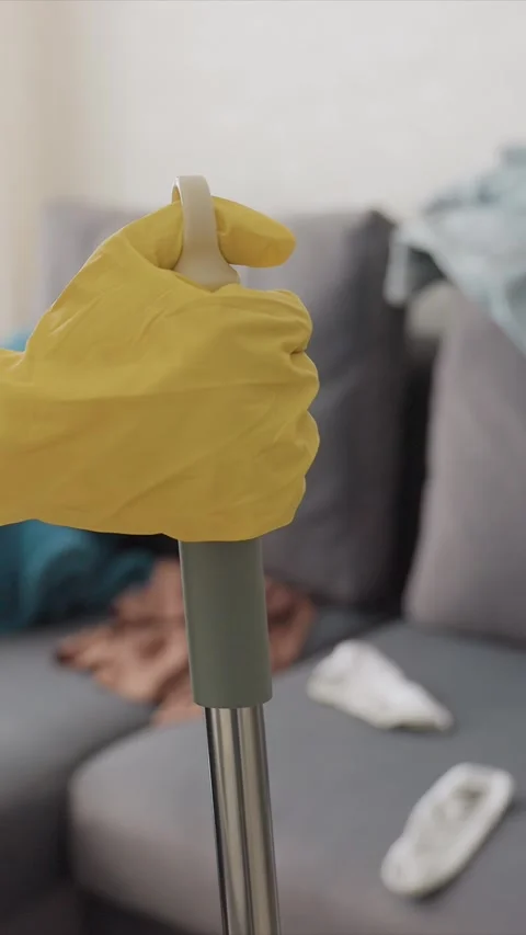 Gloved Hands with Cleaning Tool in Untidy Close up with glove yellow hand rod Vídeo Stock 346785745