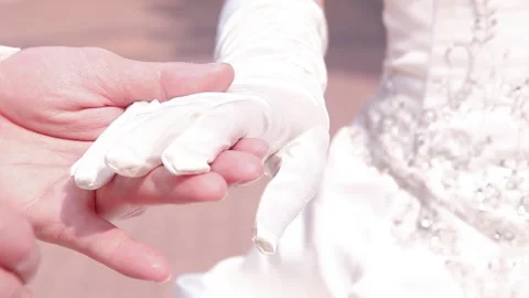 Gloved hands connecting during an outdoor wedding Stock Footage 323794398
