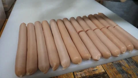 Gloved Hands Cutting Raw Sausages on White Chopping Board with Cleaver 스톡 동영상 343587587