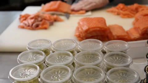 Gloved hands expertly cut salmon into perfect, even slices The chef's precision Stock Footage 285372269