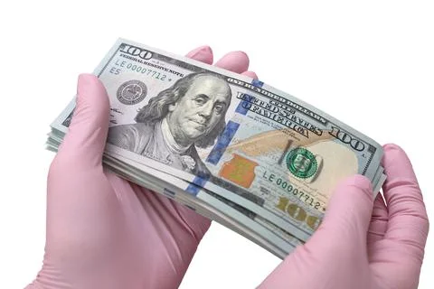 Gloved hands holding a pack of dollars Stock Photos