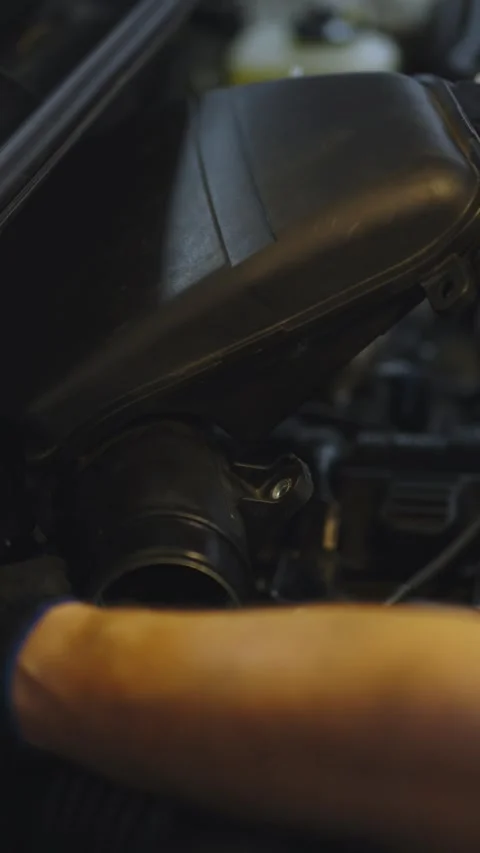 Gloved hands installing a black plastic air filter box assembly inside a car Stock Footage 336711232
