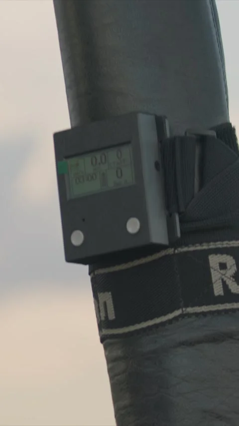 Gloved hands operating measurement device with parachute icon against sky Vidéo 348240619