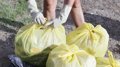 Gloved hands pack garbage bag. Stock Footage 284308655