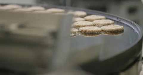 Gloved hands placing meat patties onto a hot griddle surface, Static Shot Vidéo 340043861