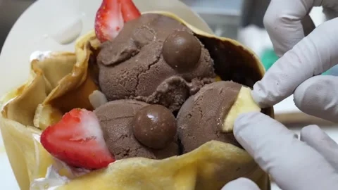 Gloved Hands Preparing Chocolate Ice Cream and Strawberry Crepe Stock Footage 345692346