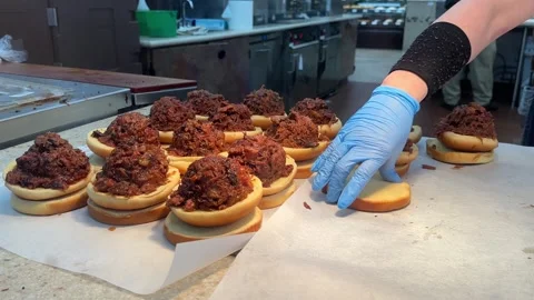 Gloved hands preparing several pulled pork sandwiches. Stock Footage 273741443