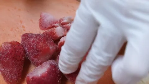 Gloved Hands Slicing Fresh Strawberries on a Cutting Board Stock Footage 345652285