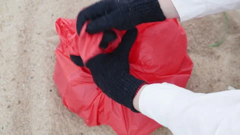 Gloved hands tying red trash bag. Stock Footage 308446622