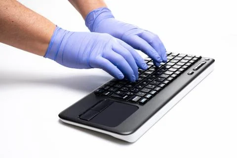Gloved hands typing on computer keyboard Foto stock