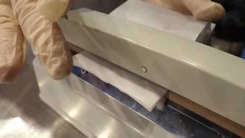 Gloved Hands Using Impulse Heat Sealer to Seal Sterile Packaging Close Up Stock Footage 345291662