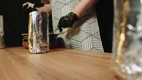 Gloved male hand putting portion of battery in the bottom of foilwrapped jar Stock Footage 330536899