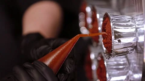 Gloved pastry chef's hands pouring filling into cupcake, vertical video Stock Footage 297623940