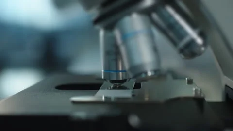 Gloved Scientist Adjusting Microscope Objective on Glass Slide Stock Footage 338358144