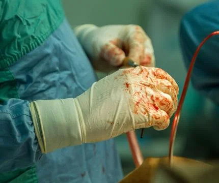 Gloved surgeon's hands Stock Photos
