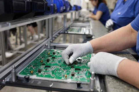 Gloved technician assembling PCB on modern SMT production line Stock Photos