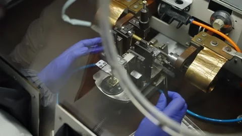 Gloved technician performs precision microelectronics assembly in a cleanroom Stock Footage 325975808