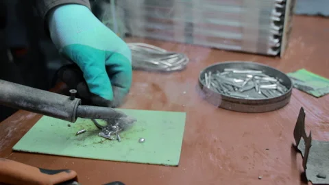 Gloved technician uses a heated tool to join small metal components, Hands on 库存影片 344643531