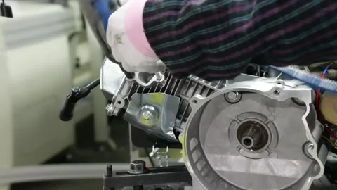 Gloved Worker Assembling Small Gasoline Engine on Factory Assembly Line Stock Footage 348591102