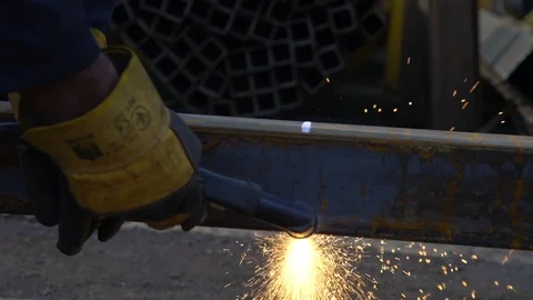 Gloved worker cuts a metal beam using a welding machine Stock Footage 113744384