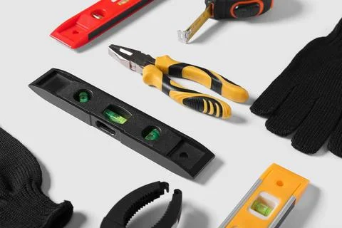 Gloves and different construction tools isolated on white background, closeup Stock Photos