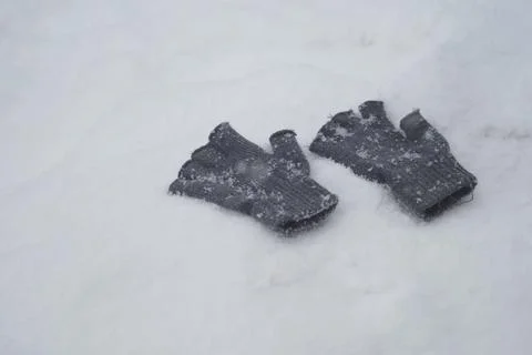 Gloves rest on snow during a winter day Stock Photos