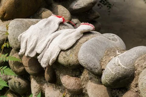 Gloves workers were left on a stone wall. Stock Photos