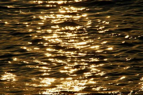 The glow of the setting summer sun reflected on the calm waves of the Baltic Sea Stock Photos