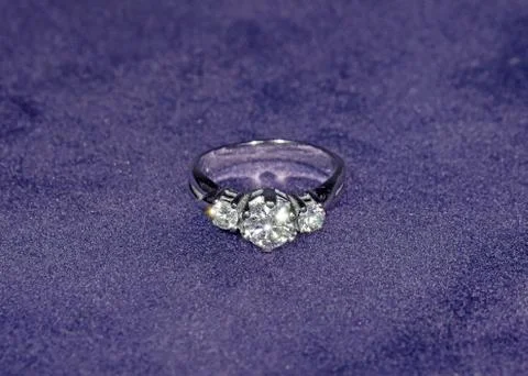 Glow Silver Diamond Ring Isolated on Violet Velvet Background Photos