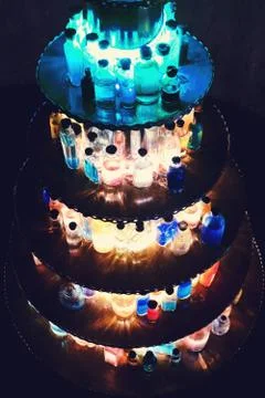 Glowing bottles of liquid on a circular base, black background Stock Photos