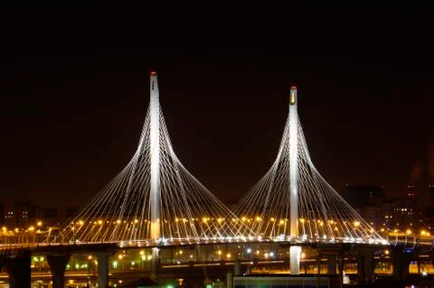 Glowing cable-stayed bridge supports against the night sky. Stock Photos