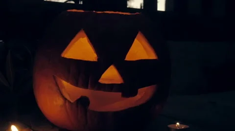Glowing Candles Surround a Spooky Jack o'lantern Pumpkin Stock Footage 68931368